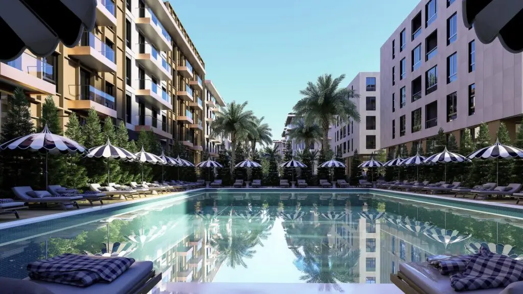 Render of a long pool lined with striped parasols and sun loungers between Palm Paradise apartment buildings and palm trees
